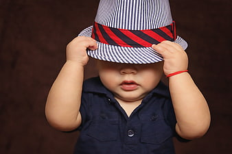 Cute baby boy wearing a striped fedora hat