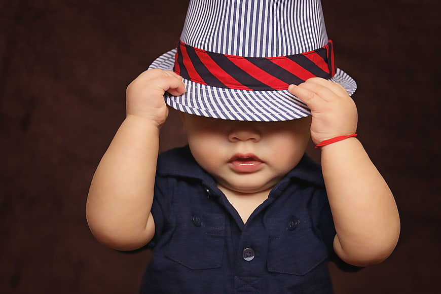 Cute baby boy wearing a striped fedora hat