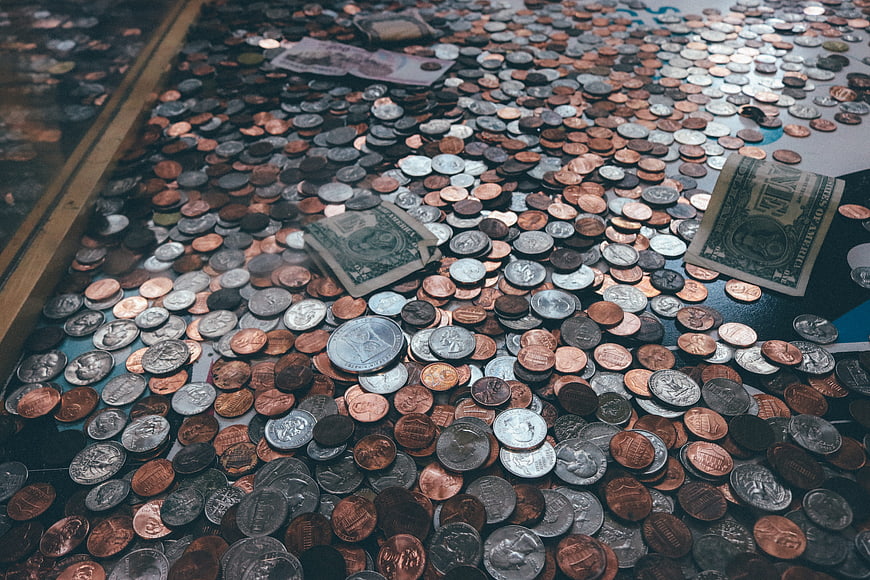Pile of US coins and dollar bills in a donation box