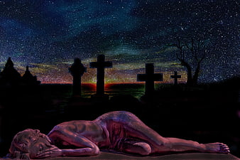 Statue of fallen figure in graveyard under starry night sky