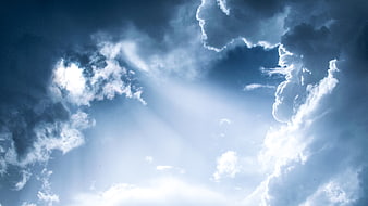 Dramatic Blue Sky with Sun Rays Breaking Through Clouds