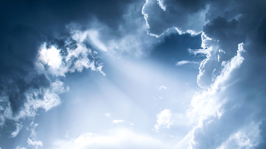 Dramatic Blue Sky with Sun Rays Breaking Through Clouds