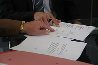 Businessmen reviewing contract documents at office desk
