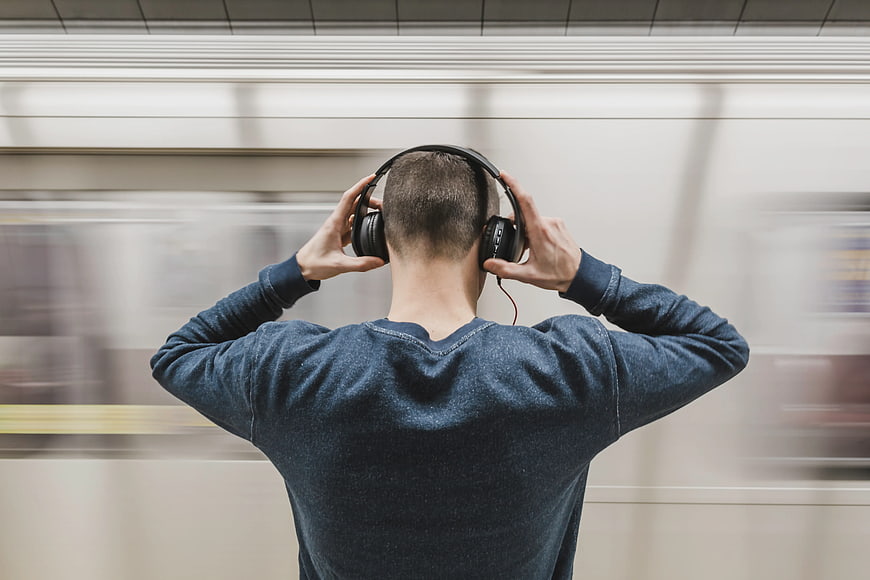 Man listening to music on headphones at subway station