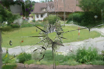 Broken window glass with heart-shaped hole in garden