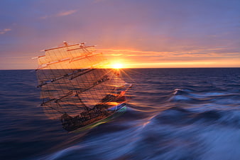 Vintage sailing ship on ocean waves at sunset