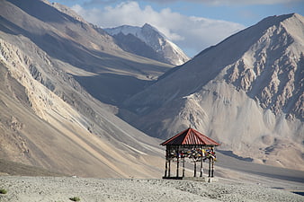 Mountain Landscape With Small Red Roofed Shelter In Arid Valley