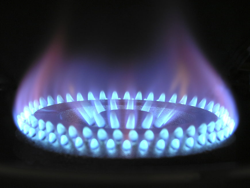 Close-up of blue gas flame on kitchen stove burner