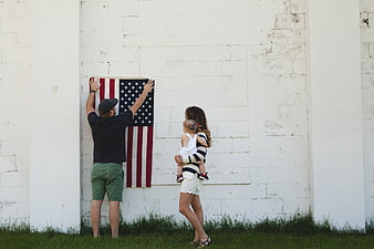 Family Hanging American Flag on White Wall