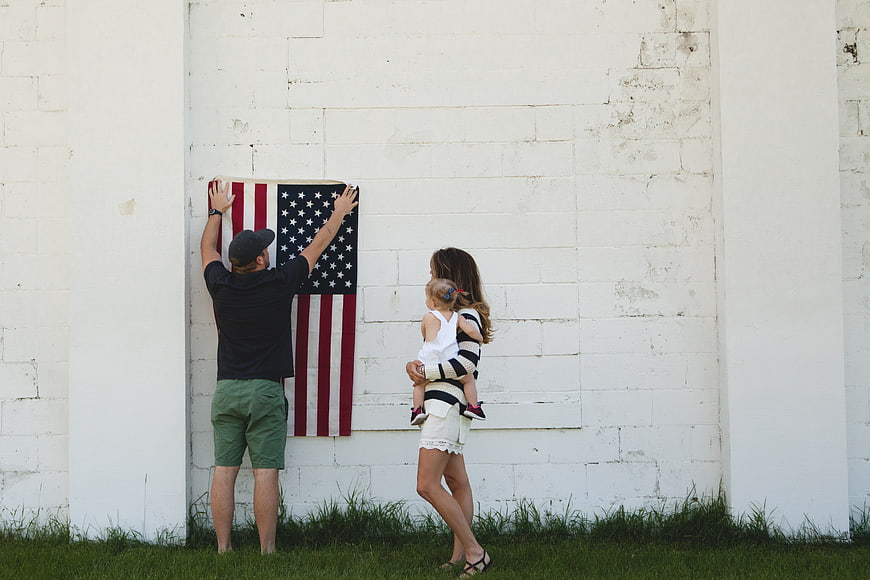 Family Hanging American Flag on White Wall
