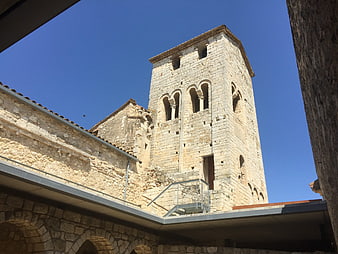 Low angle view of ancient Romanesque stone church tower