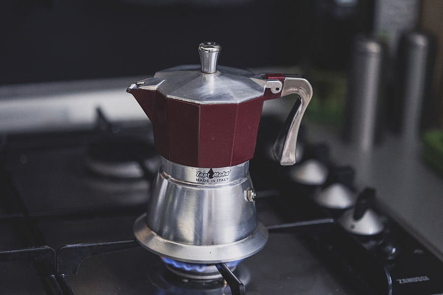 Red Moka Pot Brewing Coffee on Gas Stove