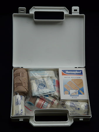 Open white first aid kit with bandages and plasters