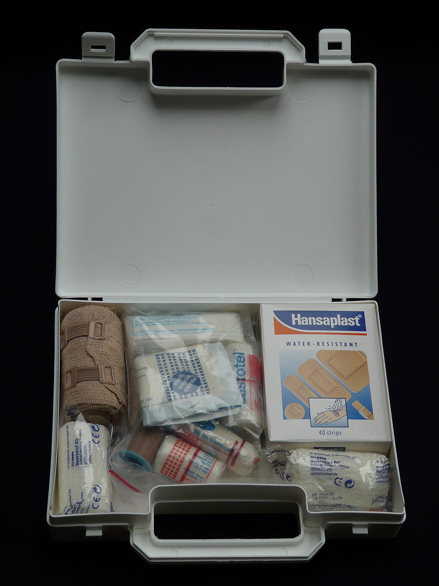 Open white first aid kit with bandages and plasters