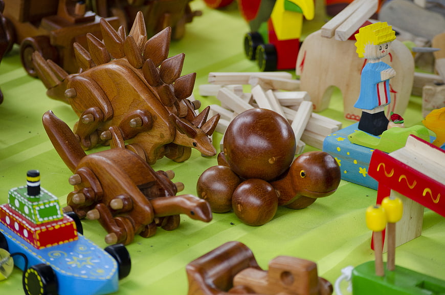 Collection of wooden dinosaur toys and blocks on green surface