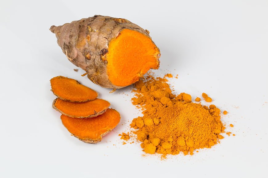 Fresh Turmeric Root, Slices, and Powder on White Background