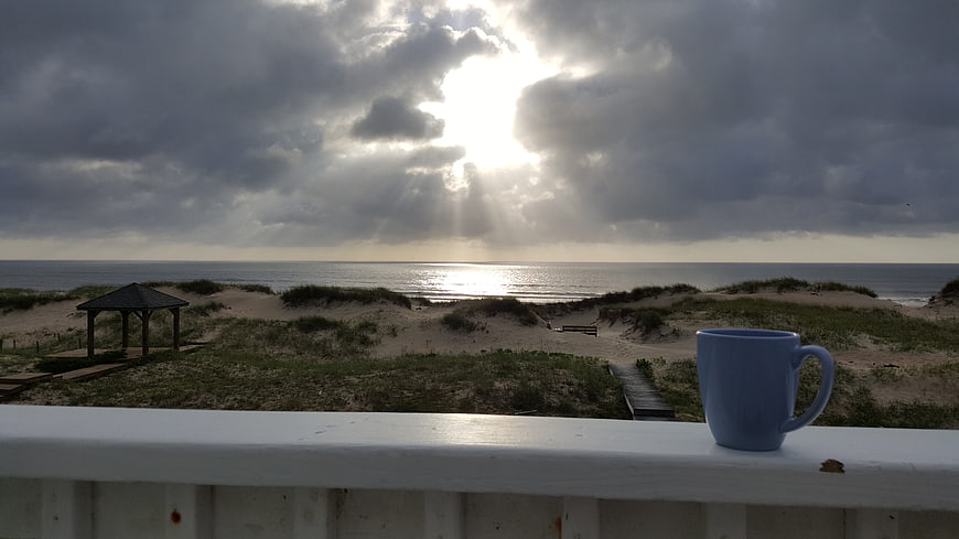 Blue Coffee Mug On Balcony Railing With Ocean Sunrise View