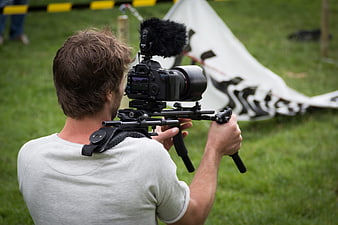 Camera Operator Filming Event with DSLR and Gimbal Stabilizer