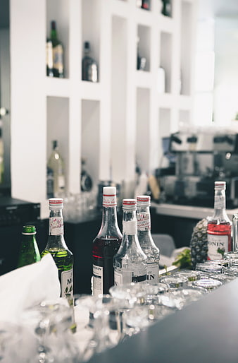 Monin syrup bottles and glasses on a modern bar counter