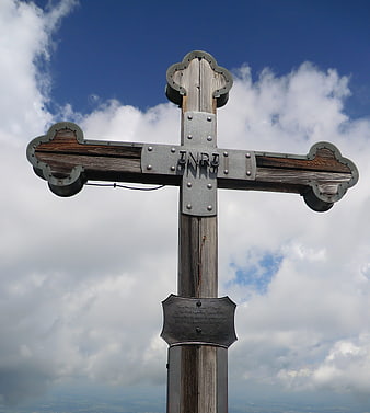 Wooden Mountain Cross with INRI Inscription Against Blue Sky