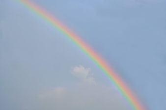Vibrant Rainbow Arc Against Soft Blue Sky