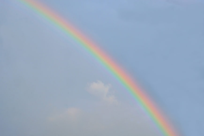 Vibrant Rainbow Arc Against Soft Blue Sky