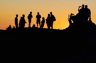 Silhouette of Hikers on Mountain Ridge at Sunset