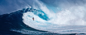 Surfer riding inside a massive blue ocean wave barrel