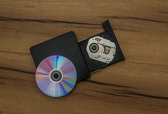 External CD DVD Drive and Disc on Wooden Surface