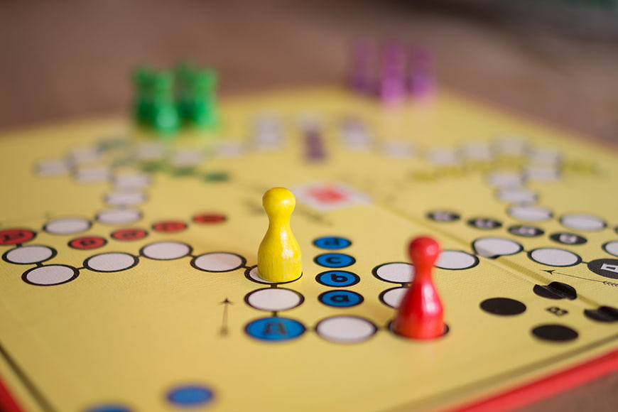 Close-up of colorful game pieces on a yellow board game