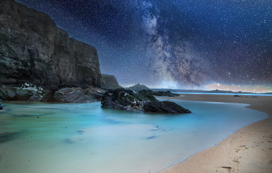 Milky Way over Coastal Cliffs and Sandy Beach at Night