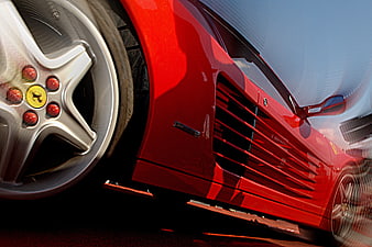 Close-up of red Ferrari side vent and wheel