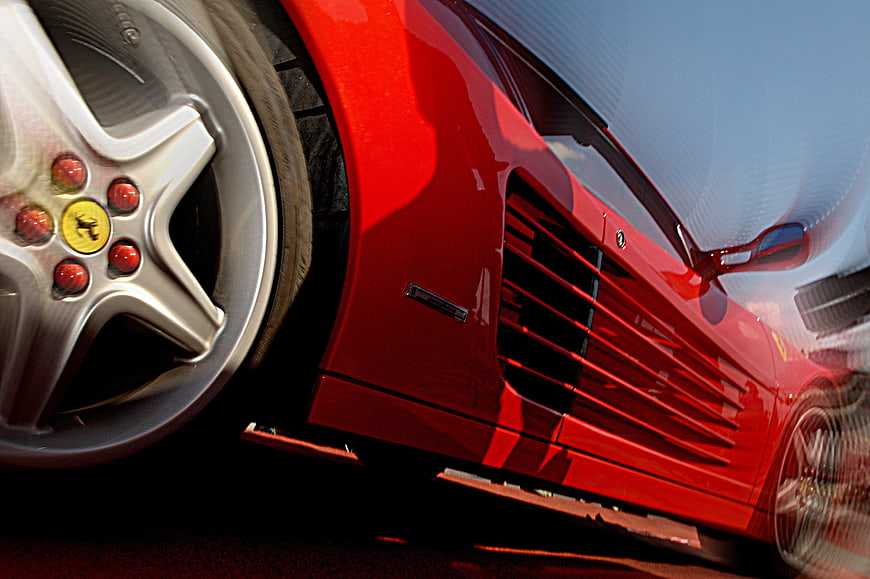 Close-up of red Ferrari side vent and wheel