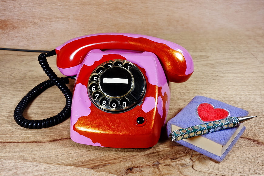 Vintage red and pink rotary phone with heart notebook