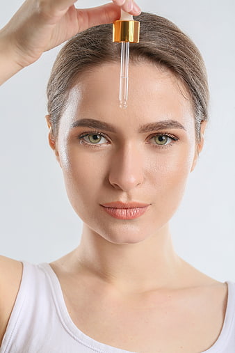 Woman applying facial serum with dropper