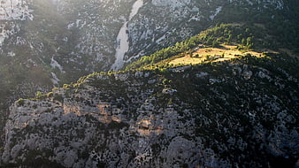 Aerial view of rugged mountain landscape with isolated house