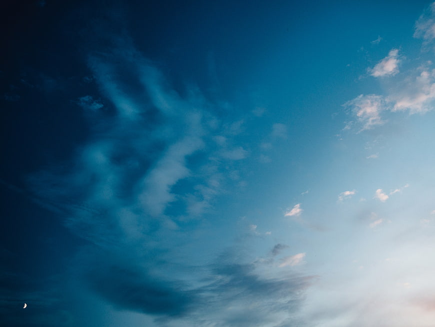 Dramatic Blue Sky with Wispy Clouds and Crescent Moon