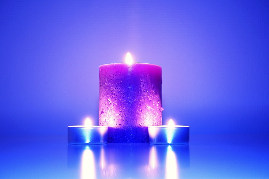 Purple Candle with Tea Lights on Blue Background