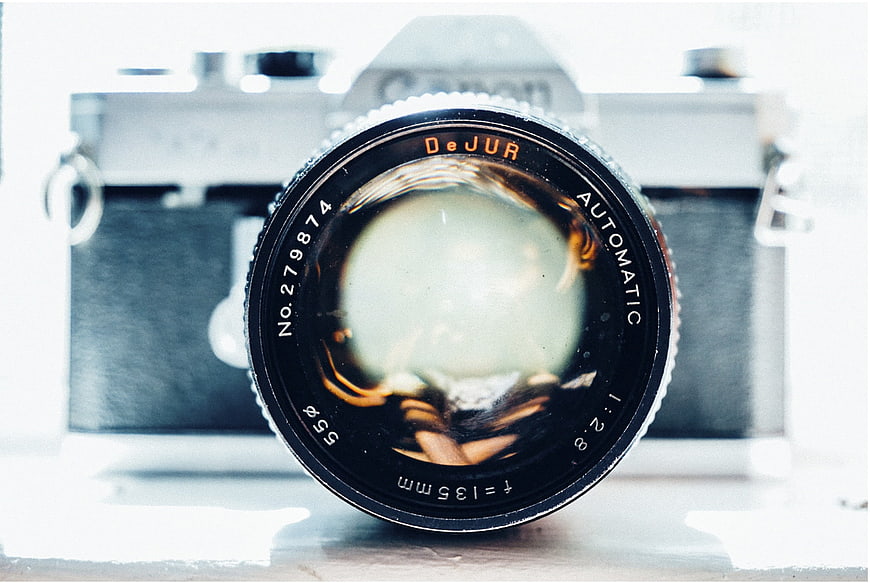 Close-up of vintage DeJUR camera lens with blurred background