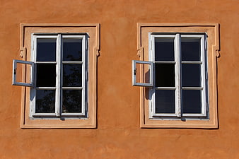Symmetrical white windows on orange stucco wall