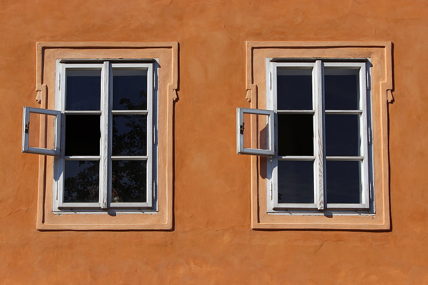 Symmetrical white windows on orange stucco wall
