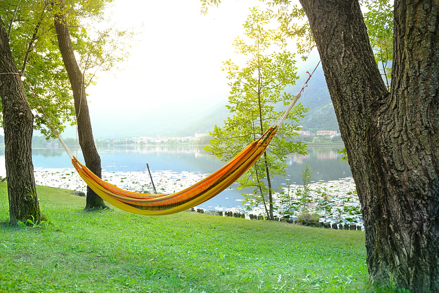 Colorful Hammock Hanging Between Trees by a Lake