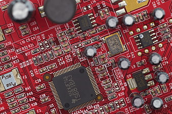 Close-up of red computer motherboard with microchip and electronic components