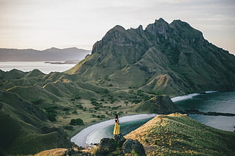 Woman in Yellow Dress Overlooking Mountainous Coastal Landscape