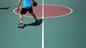 Basketball player dribbling on outdoor court with copyspace