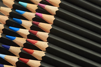 Close-up of black colored pencils with vibrant tips