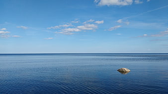 Minimalist Ocean Horizon With Single Rock And Blue Sky