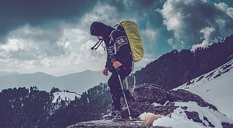 Hiker with Backpack on Snowy Mountain Peak