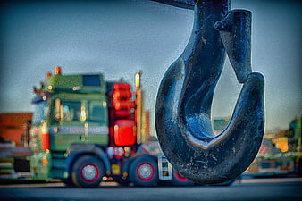 Close-up of heavy-duty crane hook with blurred truck background