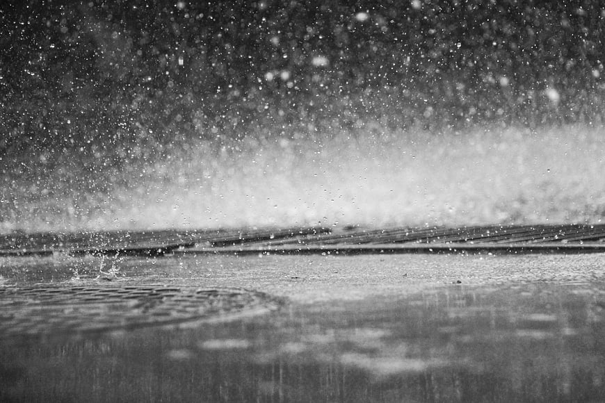 Black and white rain splashing on wet pavement